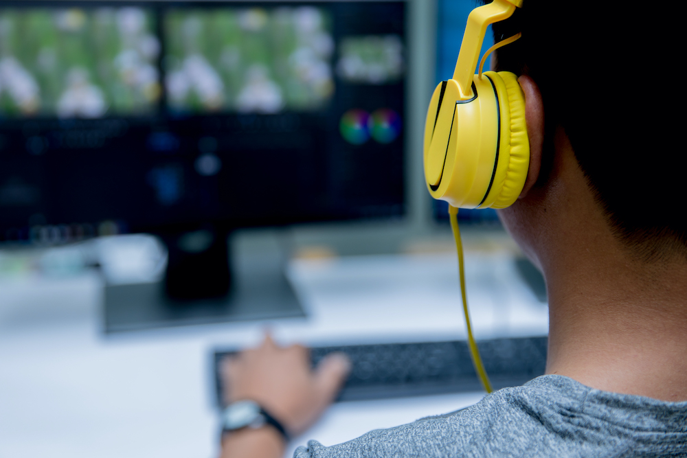 Computer video editing and yellow headset